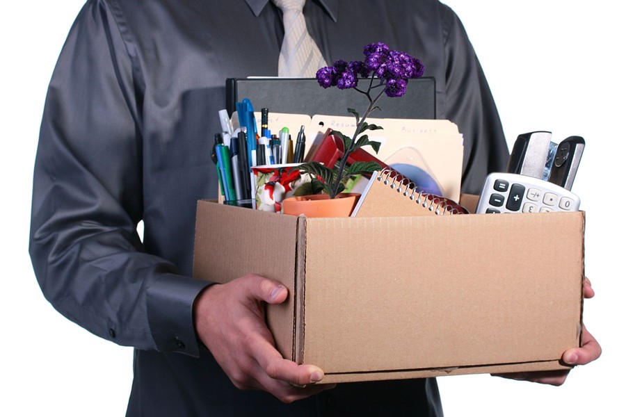 Dismissal, the man has control over a cardboard box with personal office things.